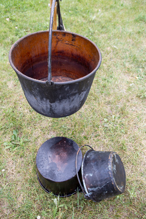 A large kettle hangs from a tripod